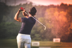 Golfer hitting golf shot with club on course vintage color tone